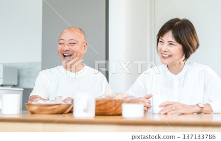 Smiling senior couple having a conversation with their family while drinking coffee Smiling senior couple having a conversation with their family while drinking coffee 137133786