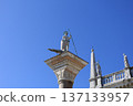 A column with a statue of a saint and the blue sky of Venice 137133957