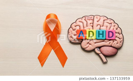 ADHD brain illustration with an orange ribbon on a wooden background, symbolizing ADHD Awareness Month and neurodiversity 137133959