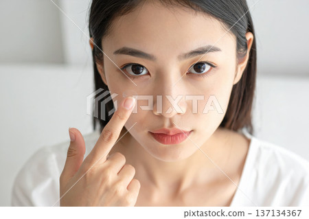 女子將隱形眼鏡戴在手指上 137134367