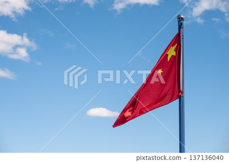 The People's Republic of China national flag blowing by wind against blue sky. The People's Republic of China national flag blowing by wind against blue sky. 137136040