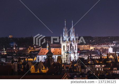 Evening panorama of Prague Old Town with glowing gothic towers of Church of Our Lady before Tyn above historic city roofs in Czech Republic 137136125