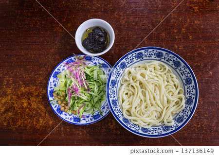 Overhead view on unmixed serving of the popular Zhajiangmian, noodle with garnish and paste in restaurant. Overhead view on unmixed serving of the popular Zhajiangmian, noodle with garnish and paste in restaurant. 137136149