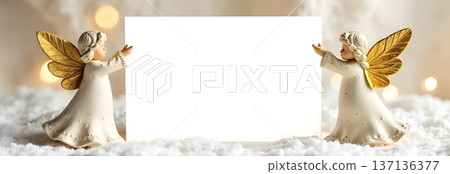 Christmas angels holding blank card in snowy winter background 137136377