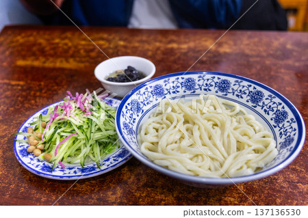 An unmixed serving of the popular Zhajiangmian, noodle with garnish and paste in restaurant. 137136530