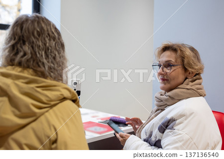 Mobility. Mature women walking side by side discussing daily topics with expressive gestures  137136540