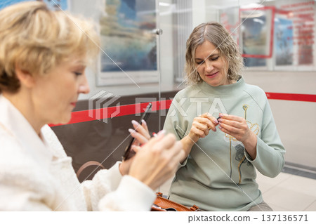 Preparation. Female friends applying lipstick and fixing hairstyle near wardrobe mirrors in lobby interior before social meeting. Preparation. Female friends applying lipstick and fixing hairstyle near wardrobe mirrors in lobby interior before social meeting. 137136571