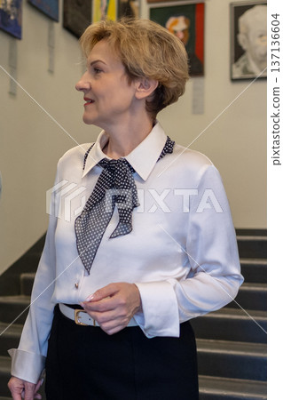 Woman appreciating contemporary art inside modern museum space and while viewing framed paintings. Woman appreciating contemporary art inside modern museum space and while viewing framed paintings. 137136604