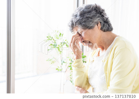 Senior woman holding her eyes 137137810