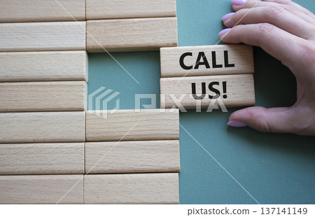 Call Us symbol. Wooden blocks with words Call Us. Businessman hand. Beautiful grey green background. Business and Call Us concept. Copy space. 137141149