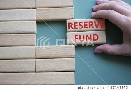 Reserve Fund symbol. Concept word Reserve Fund on wooden blocks. Beautiful grey green background. Businessman hand. Business and Reserve Fund concept. Copy space Reserve Fund symbol. Concept word Reserve Fund on wooden blocks. Beautiful grey green background. Businessman hand. Business and Reserve Fund concept. Copy space 137141152