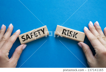 Safety or Risk symbol. Concept word Safety or Risk on wooden blocks. Businessman hand. Beautiful blue background. Business and Safety or Risk concept. Copy space Safety or Risk symbol. Concept word Safety or Risk on wooden blocks. Businessman hand. Beautiful blue background. Business and Safety or Risk concept. Copy space 137141165