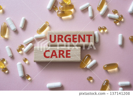 Urgent Care symbol. Concept word Urgent Care on wooden blocks. Beautiful pink background with pills. Medicine and Urgent Care concept. Copy space 137141208