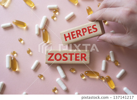 Herpes Zoster symbol. Concept word Herpes Zoster on wooden blocks. Beautiful pink background with pills. Doctor Hand. Medicine and Herpes Zoster concept. Copy space 137141217