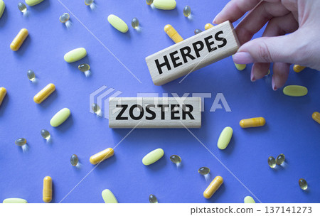 Herpes Zoster symbol. Concept word Herpes Zoster on wooden blocks. Beautiful purple background with pills. Doctor Hand. Medicine and Herpes Zoster concept. Copy space 137141273