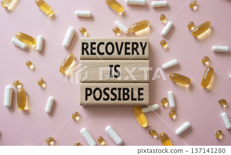 Recovery is possible symbol. Concept words Recovery is possible on wooden blocks. Beautiful pink background with pills. Healthcare and Recovery is possible concept. Copy space. Recovery is possible symbol. Concept words Recovery is possible on wooden blocks. Beautiful pink background with pills. Healthcare and Recovery is possible concept. Copy space. 137141280