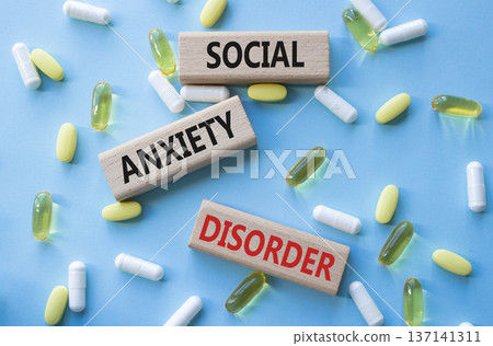 Social Anxiety Disorder symbol. Concept words Social Anxiety Disorder on wooden blocks. Beautiful blue background with pills. Healthcare and Social Anxiety Disorder concept. Copy space. Social Anxiety Disorder symbol. Concept words Social Anxiety Disorder on wooden blocks. Beautiful blue background with pills. Healthcare and Social Anxiety Disorder concept. Copy space. 137141311