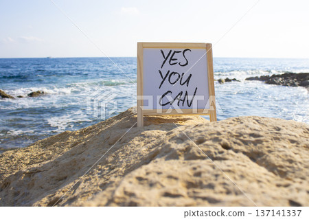 Yes You Can symbol. Concept words Yes You Can on white chalk blackboard blocks. Beautiful sea background. Business and Yes You Can concept. Copy space. Yes You Can symbol. Concept words Yes You Can on white chalk blackboard blocks. Beautiful sea background. Business and Yes You Can concept. Copy space. 137141337