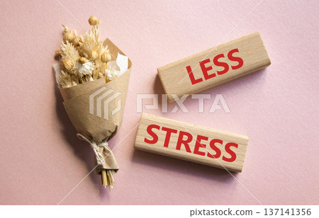 Less stress symbol. Wooden blocks with words Less stress. Beautiful pink background with bouquet of flowers. Healthcare and Less stress concept. Copy space. Less stress symbol. Wooden blocks with words Less stress. Beautiful pink background with bouquet of flowers. Healthcare and Less stress concept. Copy space. 137141356