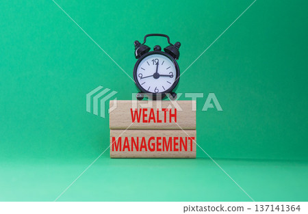 Wealth Management symbol. Concept words Wealth Management on wooden blocks. Beautiful green background with alarm clock. Business and Wealth Management concept. Copy space Wealth Management symbol. Concept words Wealth Management on wooden blocks. Beautiful green background with alarm clock. Business and Wealth Management concept. Copy space 137141364