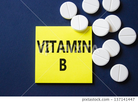 Vitamin B symbol. Concept word Vitamin B on yellow note. Beautiful deep blue background with pills. Medicine and Vitamin B concept. Copy space 137141447
