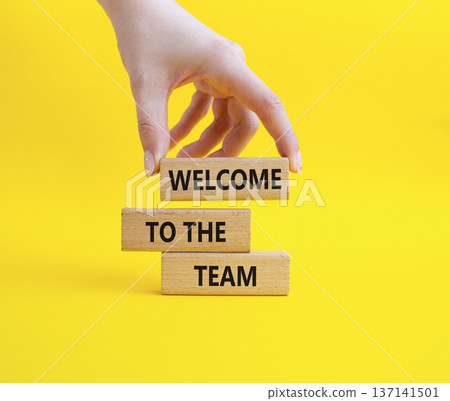 Team symbol. Wooden blocks with words Welcome to the Team. Businessman hand. Beautiful yellow background. Business and Welcome to the Team concept. Copy space. 137141501