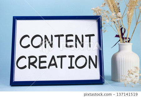 Content creation symbol. Concept words Content creation on beautiful wooden picture frame. Beautiful light blue background with flower vase. Business and Content creation concept. Copy space. Content creation symbol. Concept words Content creation on beautiful wooden picture frame. Beautiful light blue background with flower vase. Business and Content creation concept. Copy space. 137141519