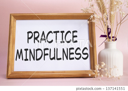 Mindfulness symbol. Concept words Practice Mindfulness on beautiful wooden picture frame. Beautiful pink background with flower vase. Medical and Psychology concept. Copy space. Mindfulness symbol. Concept words Practice Mindfulness on beautiful wooden picture frame. Beautiful pink background with flower vase. Medical and Psychology concept. Copy space. 137141551