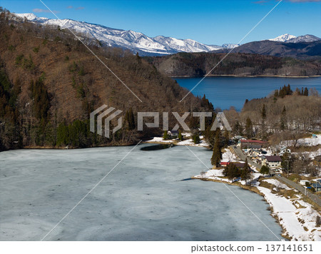 Lake Nakatsuna, completely frozen and close to thawing, and Lake Aoki, unfrozen, Omachi City, Nagano Prefecture (aerial photo taken by drone) Lake Nakatsuna, completely frozen and close to thawing, and Lake Aoki, unfrozen, Omachi City, Nagano Prefecture (aerial photo taken by drone) 137141651