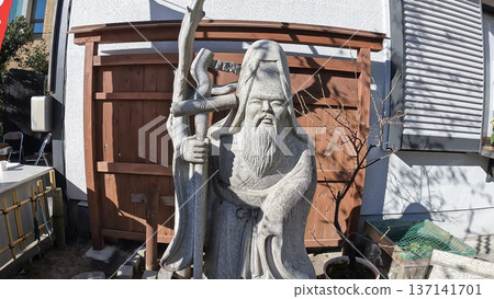 Stone statue of Jurojin, one of the Seven Lucky Gods of Senju, at Motojuku Shrine in Tokyo 137141701
