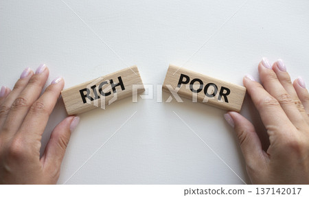 Rich vs Poor symbol. Concept word Rich vs Poor on wooden blocks. Businessman hand. Beautiful white background. Business and Rich vs Poor concept. Copy space Rich vs Poor symbol. Concept word Rich vs Poor on wooden blocks. Businessman hand. Beautiful white background. Business and Rich vs Poor concept. Copy space 137142017