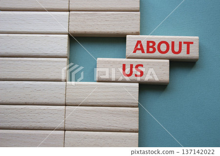 About us symbol. Wooden blocks with words About us. Beautiful grey green background. Business and About us concept. Copy space. 137142022