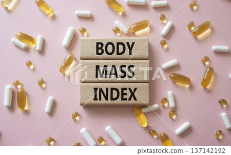 Body Mass Index symbol. Concept word Body Mass Index on wooden blocks. Beautiful pink background with pills. Medicine and Body Mass Index concept. Copy space Body Mass Index symbol. Concept word Body Mass Index on wooden blocks. Beautiful pink background with pills. Medicine and Body Mass Index concept. Copy space 137142192