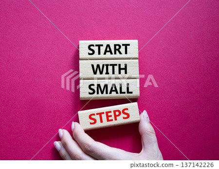 Steps symbol. Concept words Start with Small Steps on wooden blocks. Beautiful bright red background. Businessman hand. Business and Start with Small Steps concept. Copy space. 137142226