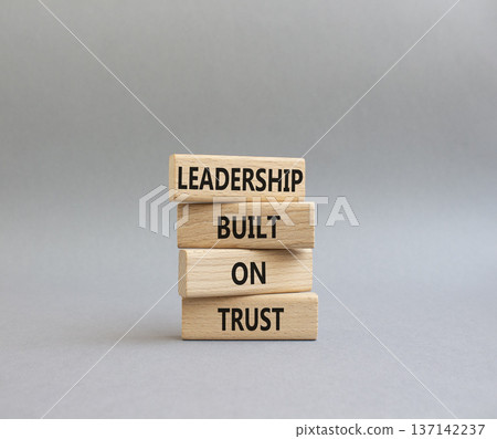 LEADERSHIP symbol. Wooden blocks with words LEADERSHIP BUILT ON TRUST. Beautiful grey background. Business and LEADERSHIP concept. Copy space 137142237