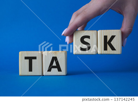 Task symbol. Concept word Task on wooden cubes. Businessman hand. Beautiful grey background. Business and Task concept. Copy space. Task symbol. Concept word Task on wooden cubes. Businessman hand. Beautiful grey background. Business and Task concept. Copy space. 137142245