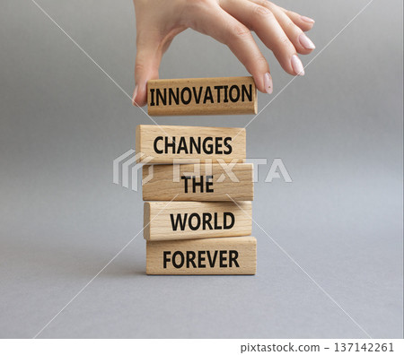 Innovation symbol. Wooden blocks with words Innovation changes the world forever. Businessman hand. Beautiful grey background. Business and Innovation concept. Copy space Innovation symbol. Wooden blocks with words Innovation changes the world forever. Businessman hand. Beautiful grey background. Business and Innovation concept. Copy space 137142261