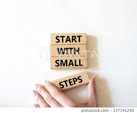 Steps symbol. Concept words Start with Small Steps on wooden blocks. Beautiful bright white background. Businessman hand. Business and Start with Small Steps concept. Copy space. 137142288