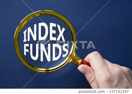 Index Funds symbol. Magnifying Glass with words Index Funds. Businessman hand. Beautiful deep blue background. Business and Index Funds concept. Copy space. 137142297