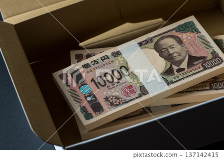 A stack of bills in a cardboard box. A dark image. A stack of bills in a cardboard box. A dark image. 137142415