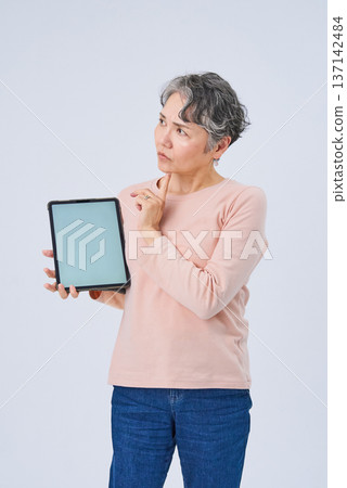 一位手持電子設備的老婦人 137142484