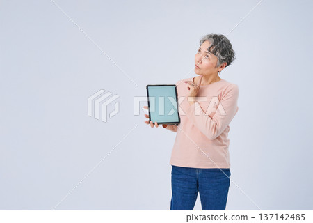 一位手持電子設備的老婦人 137142485