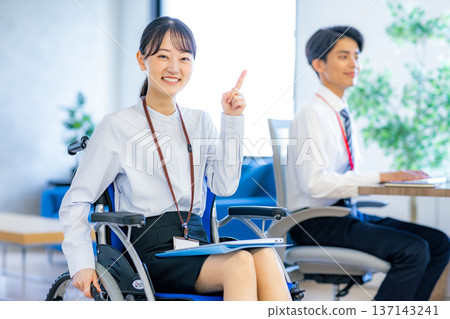 Woman in wheelchair working in office 137143241