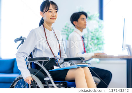 坐在輪椅上在辦公室工作的婦女 137143242