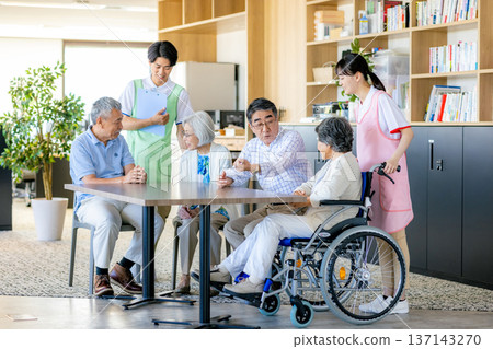 Young helpers and seniors cuddling at a nursing home Young helpers and seniors cuddling at a nursing home 137143270
