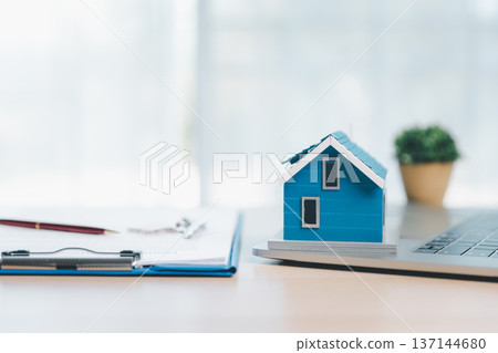 Home buying and mortgage planning concept for real estate investment and insurance, featuring a miniature house, keys, calculator, pen and contract on a bright desk in a modern office. real estate Home buying and mortgage planning concept for real estate investment and insurance, featuring a miniature house, keys, calculator, pen and contract on a bright desk in a modern office. real estate 137144680