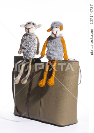 Women's beige leather bag with a toy on a white background Women's beige leather bag with a toy on a white background 137144727