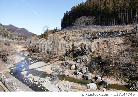 山谷中一座懸索橋，橋下有一條清澈的溪流和河岸。 137144749