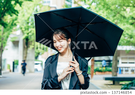 Business woman pointing a parasol 137146854