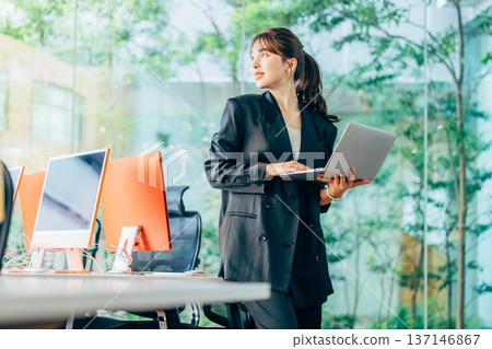 Foreign woman working on a computer in the office Foreign woman working on a computer in the office 137146867